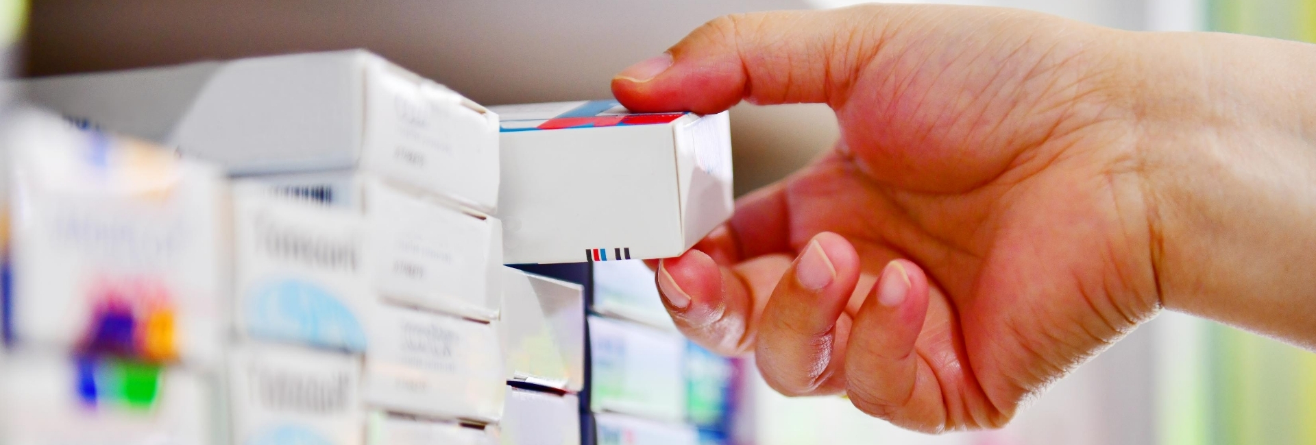 Picture of a hand taking medication from a shelf