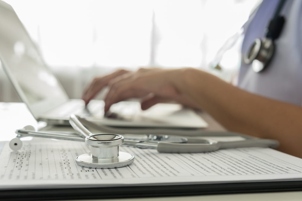 Close-up of a doctor typing on keybord in the office