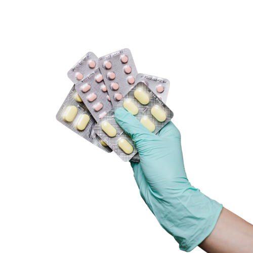 A gloved hand holding up a variety of tablets in foil packaging