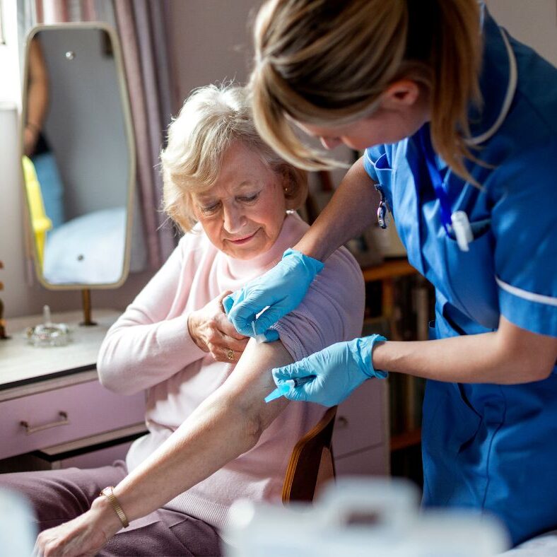 Women getting her COVID vaccination at home from an NHS nurse